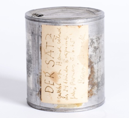 Dose „Der Satz“, theoretisches Objekt, 1965, Bild: Aufschrift: DER SATZ gesetzt von Hand während des 24 Stunden Ereignisses, Galerie Parnass 5.6.65, Bazon Brock.